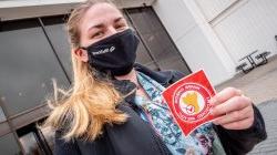 Woman holding Hawk Check sticker.